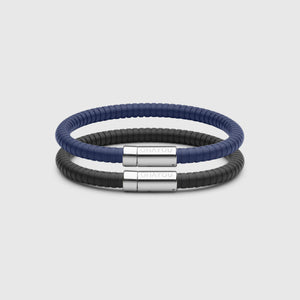 The Signature bracelet in blue with stainless steel clasp. FKM fluoroelastomer rubber – Fully waterproof. Bundled together with the Signature Bracelet in black, on white background.