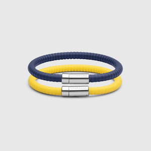 The Signature bracelet in blue with stainless steel clasp. FKM fluoroelastomer rubber – Fully waterproof. Bundled together with the Signature Bracelet in yellow on white background.