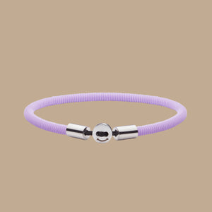 The Smile bracelet in lavender Silicon Rubber with stainless steel button clasp. Fully waterproof. Beige background.