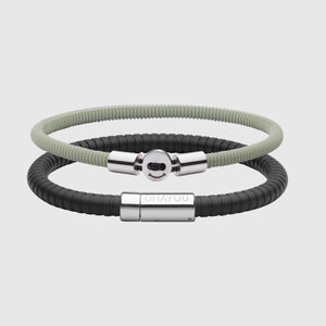 The Signature Bracelet in black with stainless steel clasp. FKM fluoroelastomer rubber – Fully waterproof. Bundled together with the Smile Bracelet in Green in silicon rubber, White background.