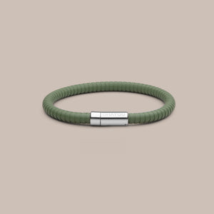 The Signature bracelet in green with stainless steel clasp. FKM fluoroelastomer rubber – Fully waterproof. Beige background.